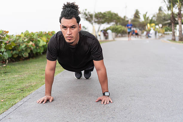 Determined young man doing push-ups outdoors in a park