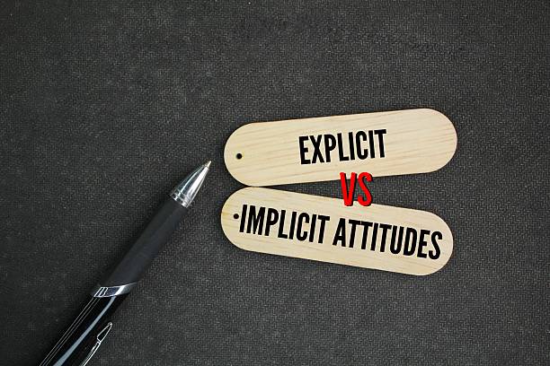 istock pen and stick with the words What is the Difference Between Explicit and Implicit Attitudes. Explicit attitudes are attitudes that are at the conscious level, are deliberately formed and are easy to s 2210715522