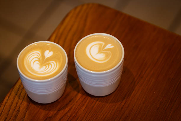 Two ceramic cups of hot latte serving at coffee shop.