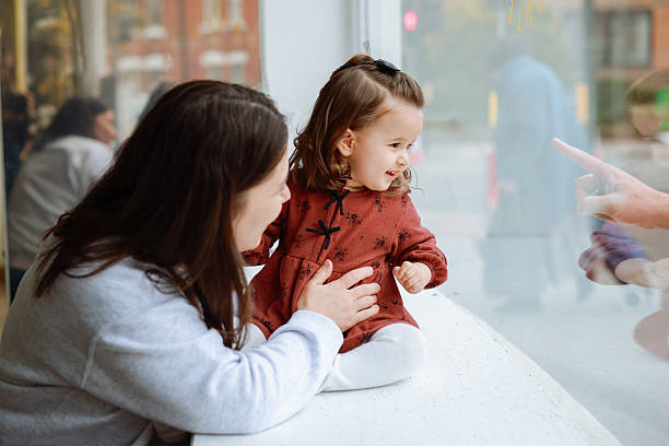 Mother and daughter looking outside the window