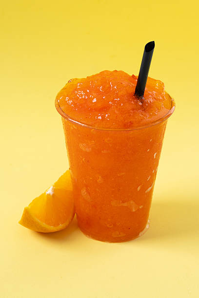 istock Orange slushie on yellow background. 2210716975