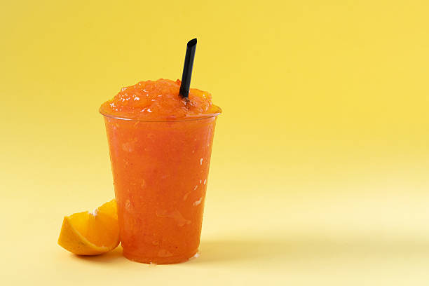 istock Orange slushie on yellow background. 2210716977