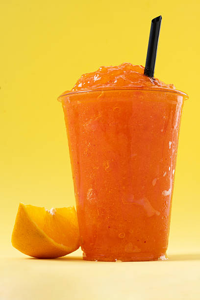 istock Orange slushie on yellow background. 2210716983