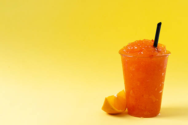 istock Orange slushie on yellow background. 2210716988