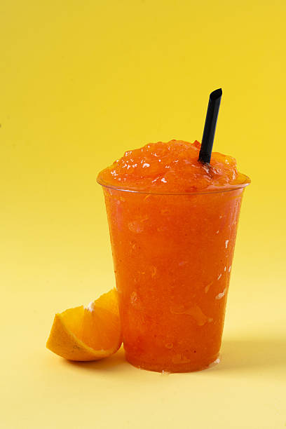 istock Orange slushie on yellow background. 2210716999
