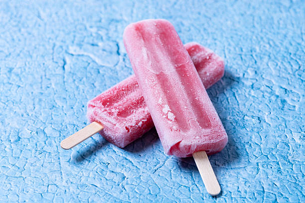 istock Red strawberry popsicles on blue background 2210717102