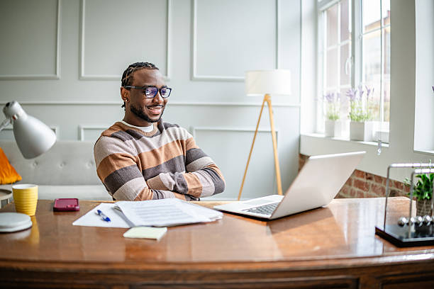 istock Young man engaged in online learning from home with a laptop during a relaxing afternoon 2210717316