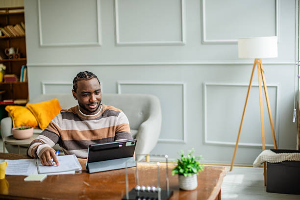 istock Young man engaged in productive online classes at home in a cozy living room setting 2210717435