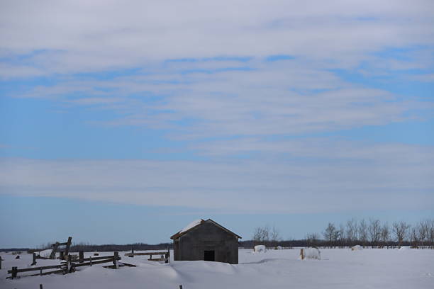In the countryside is this old, stone barn standing. The land is covered in snow during winter