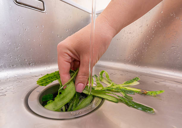 istock Food waste management: cucumber peels being processed in a garbage disposal 2210721585