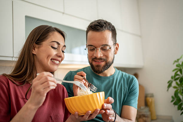 istock Happy couple sharing a meal in their modern kitchen 2210725721