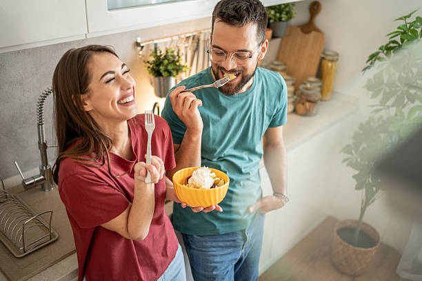 istock Happy couple enjoying a fruit salad in their kitchen 2210725723
