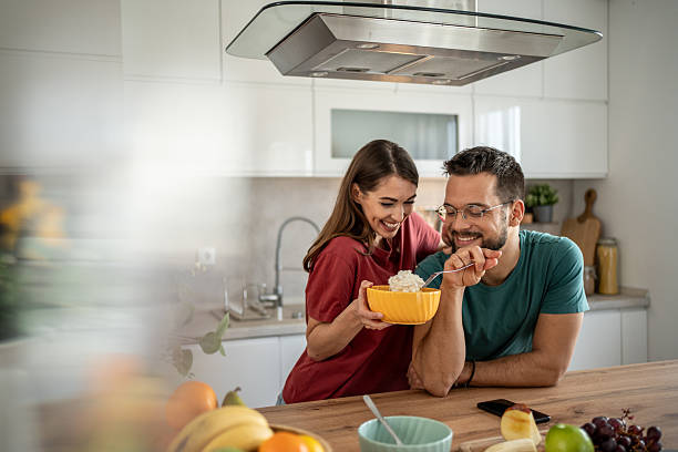 istock Happy couple sharing a meal in their modern kitchen 2210725749