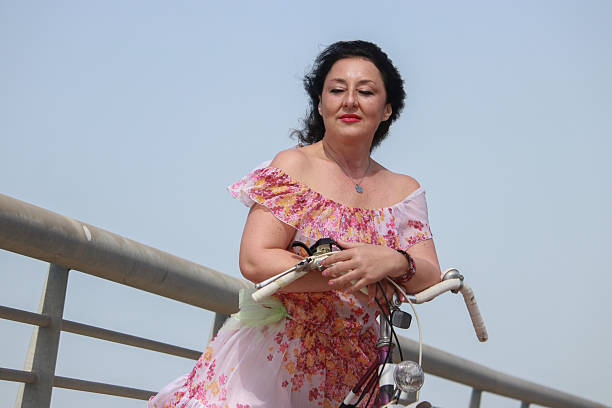 istock Mature woman ride bicycle on bridge 2210726583