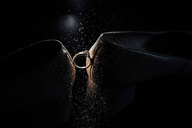 A photo of wedding rings on a flat surface in dynamic lighting.