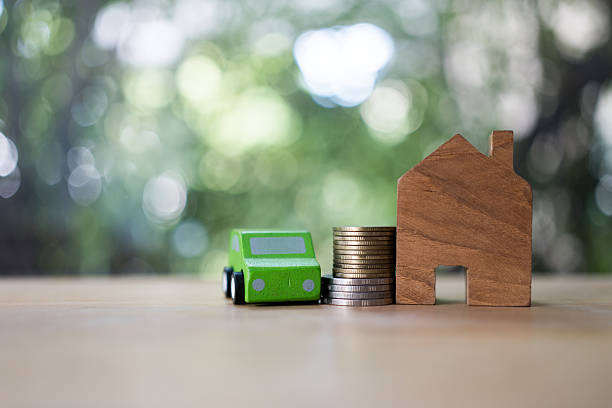 istock Car model and house model with coins on table 2210727182
