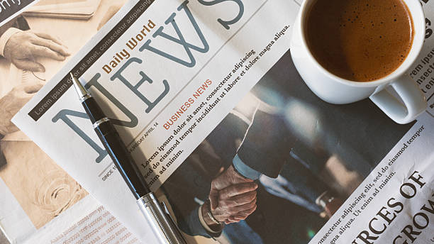 Newspaper with coffee on wooden table