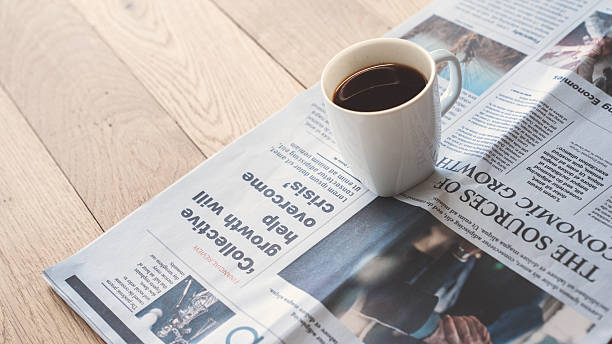 istock Newspaper with coffee on wooden table 2210730776