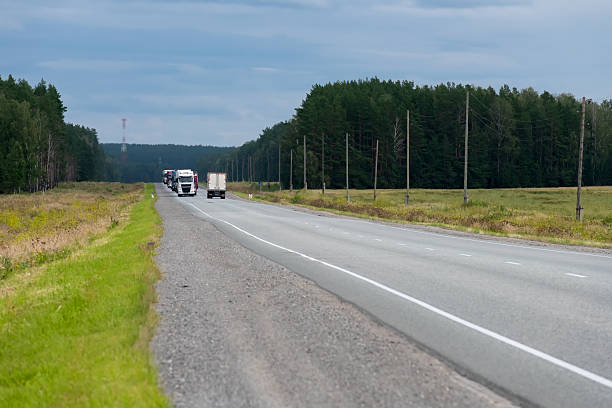 istock Trucks are moving on the highway through fields and forests 2210731327