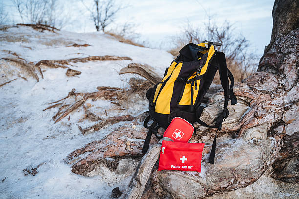 istock A bright yellow backpack is resting on a snowy hill, placed conveniently next to a vibrant red first aid kit, ready for any adventures that may lie ahead in the winter landscape 2210737178