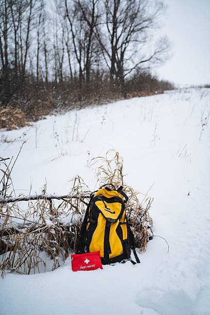 istock A vibrant yellow backpack is resting in the snow, which has blanketed the ground, while a bright red first aid kit is placed beside it, waiting to be used in case of emergencies 2210737196