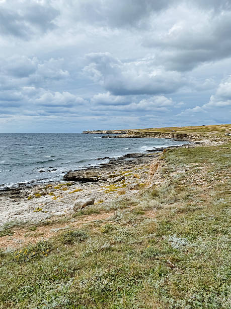 istock A dramatic cliff that majestically overlooks the vast ocean on a beautifully cloudy day, where the waves crash below and the horizon stretches out into an endless aquatic blue expanse 2210737369