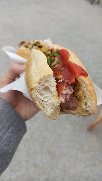 istock A hand holding a half-eaten hot dog with ketchup 2210745157