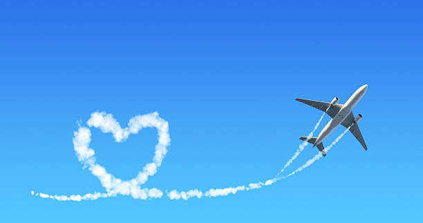 istock Horizontal background with aircraft. Airplane drawing a heart in sky. Jet flight route of aircraft in shape of a heart in blue sky. Topic of summer holiday, travel, trip abroad on vacation 2210756553