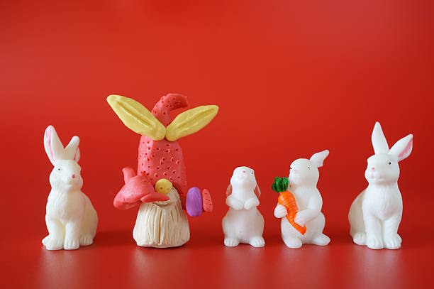istock A toy gnome made of plasticine gestures that he is making a phone call. There are rabbit figures nearby. 2210757320