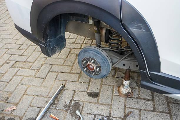 istock Changing Car Tire on Brick Pavement with Jack and Tools 2210758495