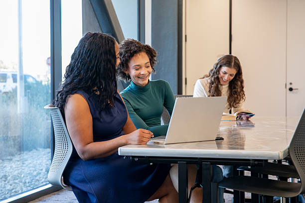 istock High school age girl uses laptop in study hall classroom while meeting with tutor after school 2210760176