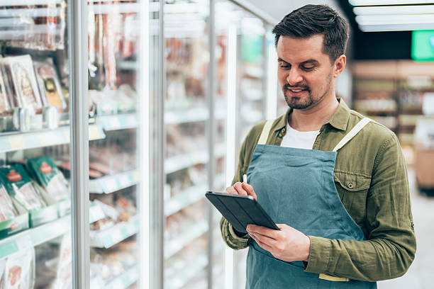istock Supermarket Employee Taking Inventory with Digital Tablet 2210760514
