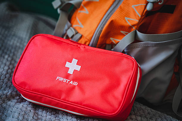 istock A bright red first aid kit, easily recognizable and wellorganized, is conveniently placed next to a sturdy backpack, ready to provide essential medical assistance in emergencies 2210761394