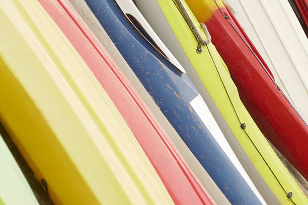 Details of several colourful kayaks lined up on the wall