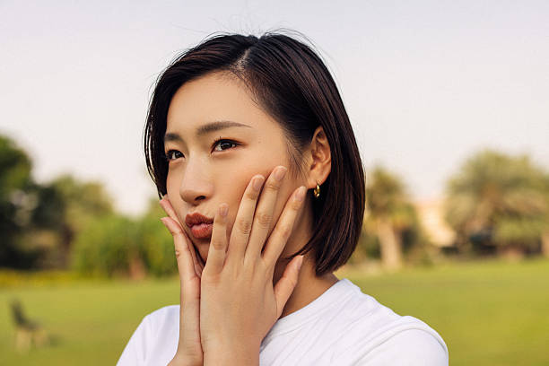 istock Woman outdoors posing with a thoughtful and playful expression in a park 2210765204