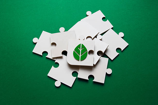istock Green Leaf Puzzle Piece Among White Pieces. Sustainable concept 2210767807