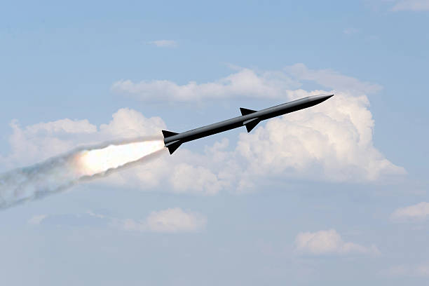 istock A combat rocket is flying above the clouds, smoke and fire from the rocket. 2210770012