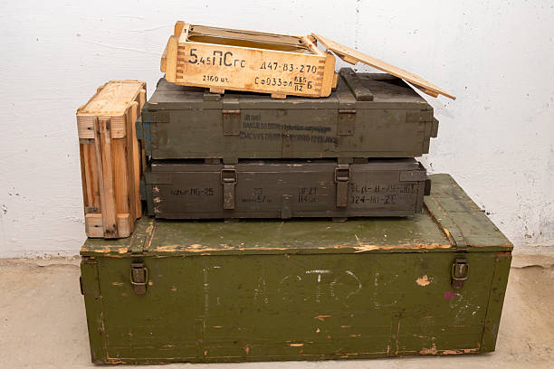 istock An open box with cartridges stands on a green box with weapons, open zinc containers. The text in Russian is the type of ammunition, caliber, type of projectile, quantity and weight. 2210770182