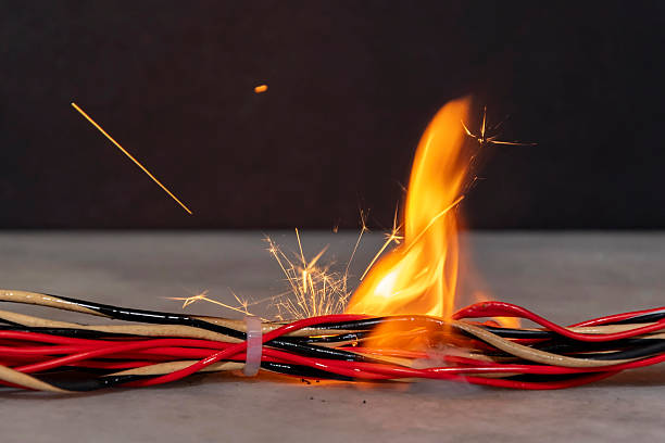 istock Ignition and fire in electrical wires on a dark background. A short circuit in the electrical wiring, the cause of the fire. Flames, sparks and smoke. 2210771942
