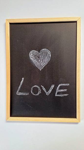 istock White background. Red heart on black chalkboard. Valentine's day. 2210773153