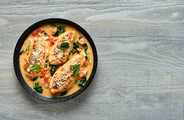 istock Chicken breast in creamy sauce with tomatoes and spinach on plate 2210774182