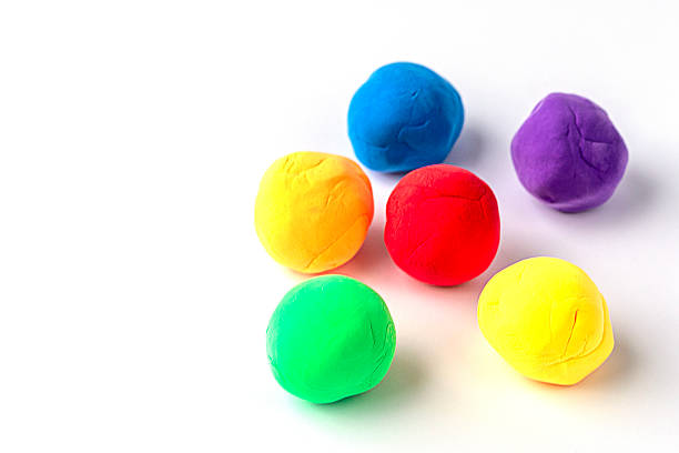 istock Collection of colorful modeling clay balls arranged on a clean white surface 2210775217
