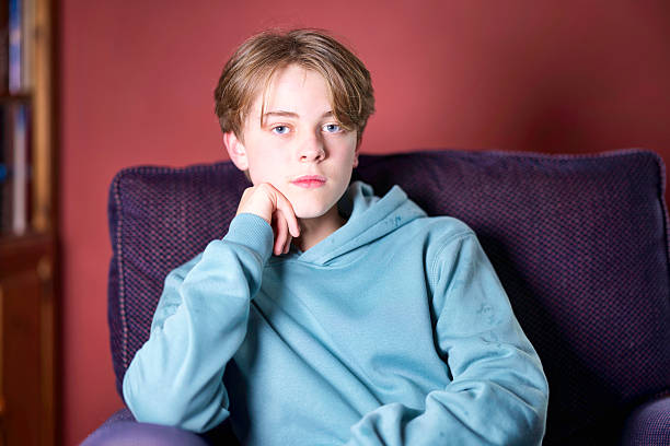 14-year-old boy at home in his favourite armchair.