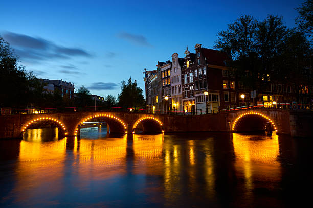 The historic architecture and canals at night in Amsterdam, The Netherlands.