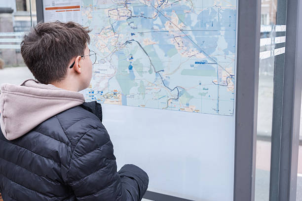 Young latin sportswoman reading a map and using a compass during an orienteering race in the countryside