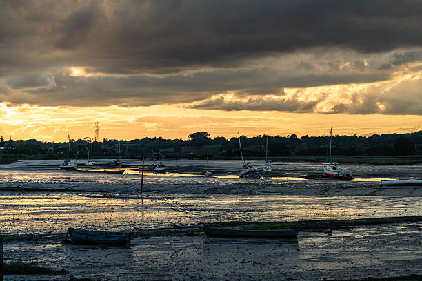 istock Sailboats rest stranded on the exposed mudflats at sunset 2210779255