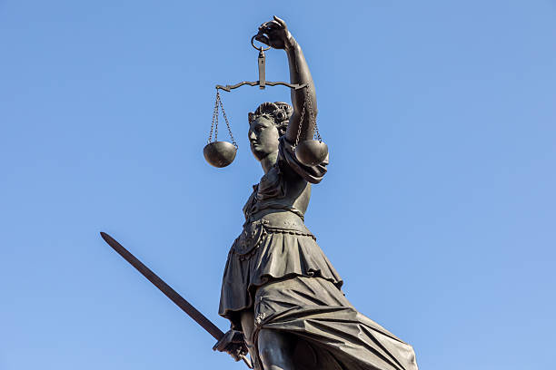 istock statue of lady justice in dramatic sky background 2210781103