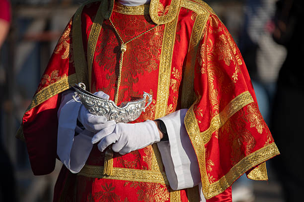 istock Altar boy in Holy Thursday procession attire carrying a chrismera 2210781532