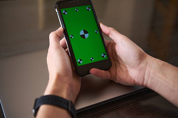 Hands Holding Smartphone With Green Screen for Digital Content Creation
