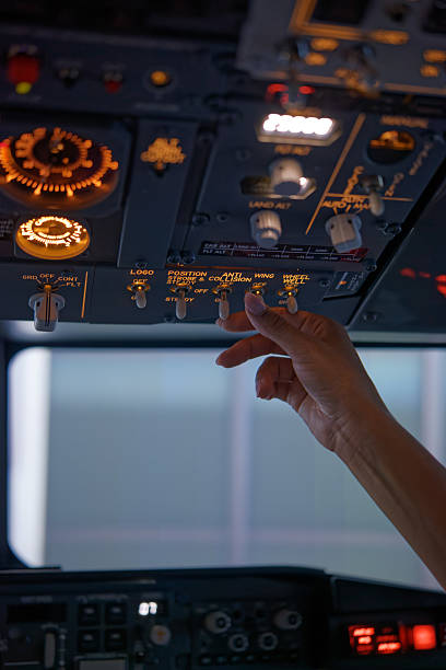 istock African American Hand Toggles Flight Instrumentation of a Passenger Jet's Upper Panel 2210790018